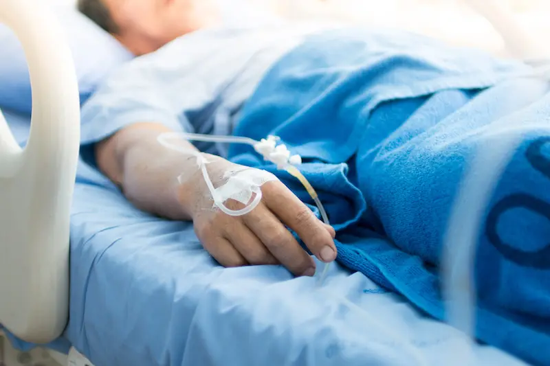 <p>Focus on the hand of a patient in hospital ward</p>\\n